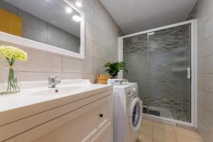 een badkamer met een wastafel en een wasmachine bij Acacias Vista Mar Arysal in Salou