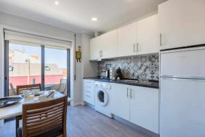 cocina con armarios blancos y nevera blanca en Vista Mare Beach Apartments by Destiny Houses, en Cortegaça
