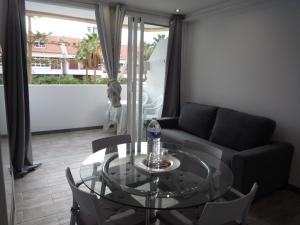 sala de estar con mesa de cristal y sofá en Apartamentos 2 Las Americas, en Playa de las Américas