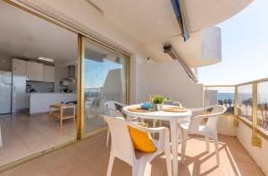 a kitchen and dining room with a white table and chairs at Acacias Vista Mar Arysal in Salou