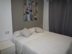 a bed with two pillows on it in a bedroom at Apartamentos 2 Las Americas in Playa de las Americas