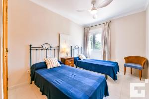 a bedroom with two beds and a chair and a window at Villa Angeles - Grupo Turis in Calpe