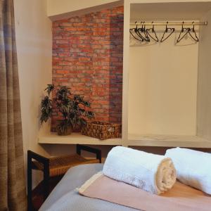 a room with a brick wall and two beds at Posada El Prado in Salta