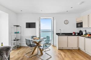 a kitchen with a table and a dining room at 14 At The Beach, Torcross in Beesands