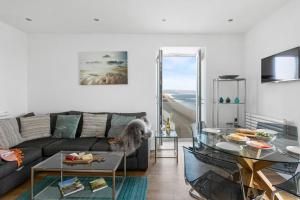 a living room with a couch and a table at 14 At The Beach, Torcross in Beesands