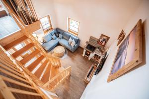 einen Blick über ein Wohnzimmer mit einem blauen Sofa in der Unterkunft Hirsch Chalet #Sauna in Lechbruck