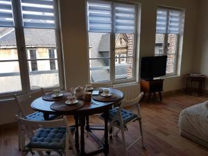 a dining room with a table and chairs and windows at LE PETIT MATELOT in Honfleur