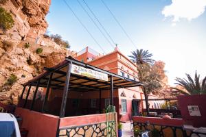 un edificio con una señal delante de él en Etoile des Gorges, en Aït Baha