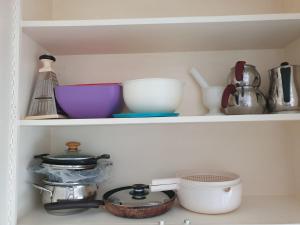 a kitchen shelf with bowls and other kitchen utensils at Sky IZMIR Center Big Suit Home in İzmir