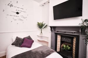 a living room with a fireplace with a tv above it at Aspen, 3 Bedrooms with Parking in Birmingham