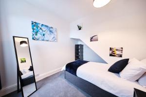 a bedroom with a white bed and a staircase at Aspen, 3 Bedrooms with Parking in Birmingham