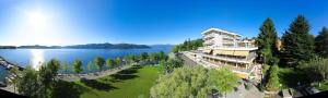 a large building on the shore of a lake at Hotel Europa in Ispra