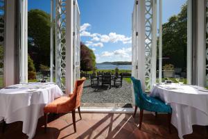 a dining room with a view of the water at Storrs Hall Hotel in Bowness-on-Windermere