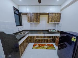 a kitchen with wooden cabinets and a counter top at Moroccan Suite Calangute Beach Vibe in Calangute