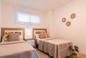 a bedroom with two beds and a window at tuGuest Velilla Apartment in Almuñécar