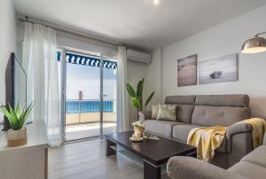 a living room with a couch and a view of the ocean at tuGuest Velilla Apartment in Almuñécar