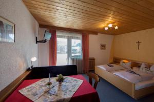 um quarto de hotel com uma cama, uma mesa e um sofá em Gästehaus Marianne Terenten em Terento