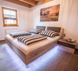 a bedroom with a bed with two pillows on it at Hirsch Chalet #Sauna in Lechbruck