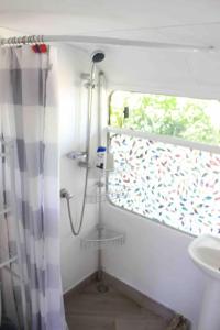 W łazience znajduje się prysznic i umywalka. w obiekcie Casa Bus los Guanacastes w mieście Veintisiete de Abril
