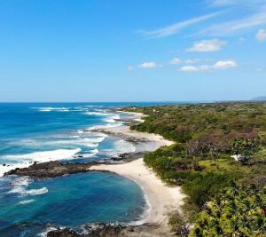 una vista aérea de una playa con el océano en Casa Bus los Guanacastes, en Veintisiete de Abril