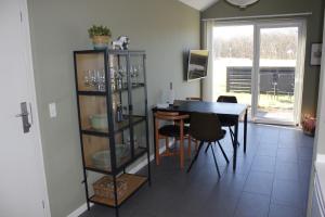 a dining room with a table and a table and chairs at Slettestrandvej Apartment - Slettestrandvej 130 nr. 3 - ID 623 in Slettestrand