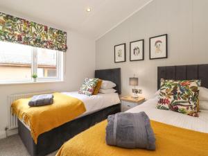 1 dormitorio con 2 camas y ventana en Thirlmere 4, en Windermere