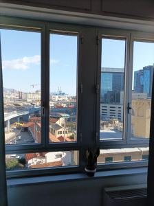 uma janela com quatro vistas de uma cidade em Residenza La Lanterna em Gênova