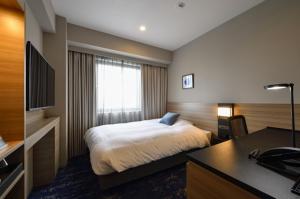 a hotel room with a bed and a desk at Hotel JAL City Miyazaki in Miyazaki