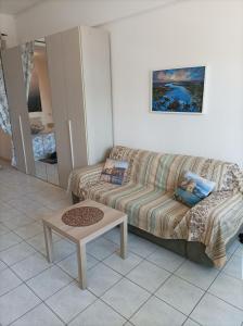 Residenza La Lanterna في جينوا: غرفة معيشة مع أريكة وطاولة