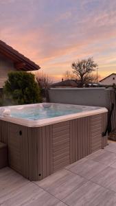 a jacuzzi tub on a patio with a sunset at A l’orée du Vuache 
