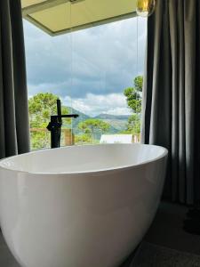 a large white bath tub in front of a window at ALTITUDE MÁXIMA - Cabanas de Altitude in Urubici