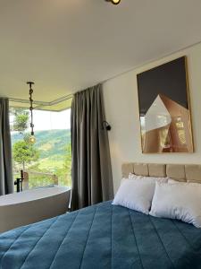 a bedroom with a tub and a bed with a view at ALTITUDE MÁXIMA - Cabanas de Altitude in Urubici