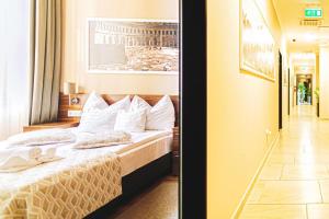2 fotos de una habitación de hotel con cama en Forum Hotel en Szombathely