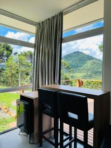 a room with a table and chairs and a large window at ALTITUDE MÁXIMA - Cabanas de Altitude in Urubici +79 photos
