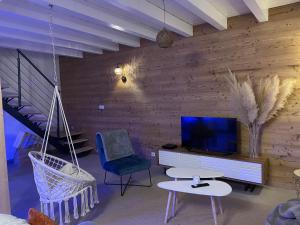 ein Wohnzimmer mit Schaukelstühlen und einem TV in der Unterkunft A l’orée du Vuache 