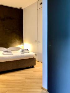 ein Schlafzimmer mit einem Bett und einer blauen Wand in der Unterkunft Fifty Eight Suite Milan Cerva in Mailand