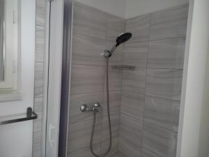 a shower with a shower head in a bathroom at Bamboo Apartman in Siófok