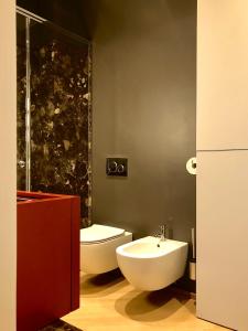 ein Bad mit einem WC und einem Waschbecken in der Unterkunft Fifty Eight Suite Milan Cerva in Mailand