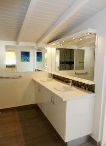 ein Badezimmer mit zwei Waschbecken und einem großen Spiegel in der Unterkunft TOUDOU DOUDOU in Deshaies
