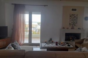 sala de estar con sofá y chimenea en Villa Dimitrios(2 independent apartments 200sq m), en Vourvourou