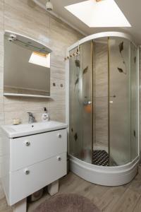 uma casa de banho com um chuveiro e um lavatório. em Denise em Dubrovnik