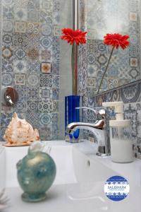 La salle de bains est pourvue d'un lavabo avec une fleur rouge. dans l'établissement SALERNUM - MONTE MARE, à Salerne