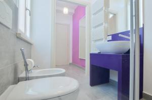La salle de bains est pourvue de toilettes blanches et d'un lavabo. dans l'établissement Villa Massari, à Milan