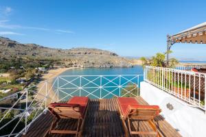 a balcony with two chairs and a view of a beach at Villa Venetoklis in Líndos