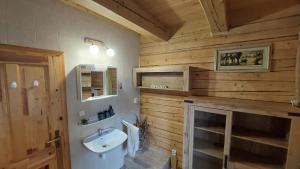 a bathroom with wooden walls and a sink and a fireplace at Chata Raj in Hrabušice