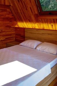 1 dormitorio con 2 camas en una cabaña de madera en ADRASAN HİMERA APART & BUNGALOW, en Adrasan
