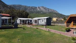 a row of houses with a mountain in the background at ADRASAN HİMERA APART & BUNGALOW in Adrasan