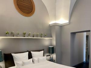 1 dormitorio con 1 cama con almohadas blancas en SA Suites, en Trepuzzi