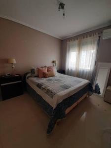1 dormitorio con cama con almohadas y ventana en Departamento Complejo Alto Villasol Amoblado 3 personas en Córdoba