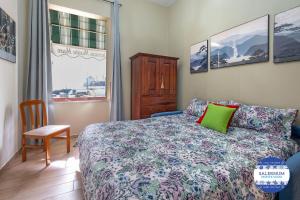 a bedroom with a bed and a chair and a window at SALERNUM - MONTE MARE in Salerno